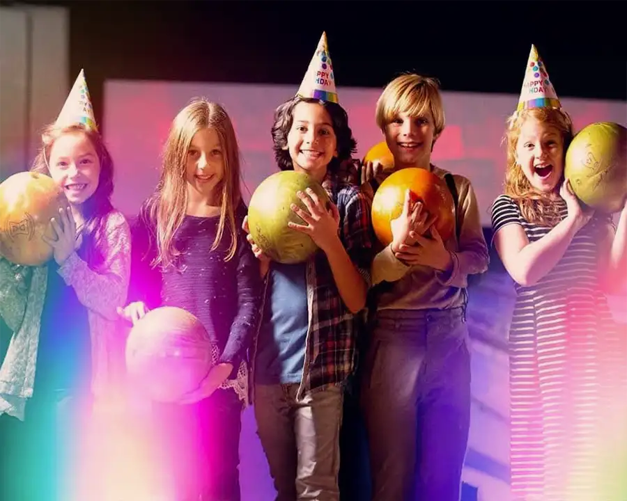 Kids wearing party hats and holding bowling balls at a birthday party at Championship Lanes in Anderson, IN