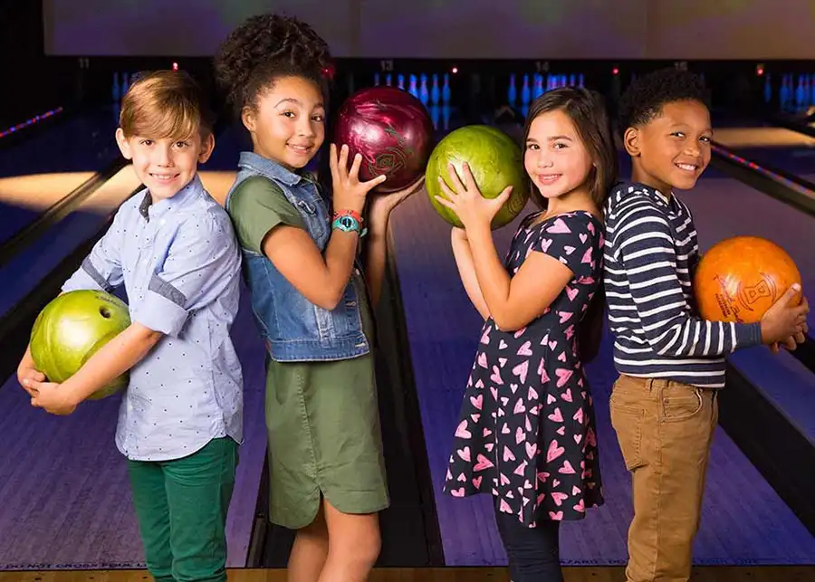 Kids posing with bowling balls in front of the lanes at Championship Lanes in Anderson, IN - Ultimate Unlimited Parties