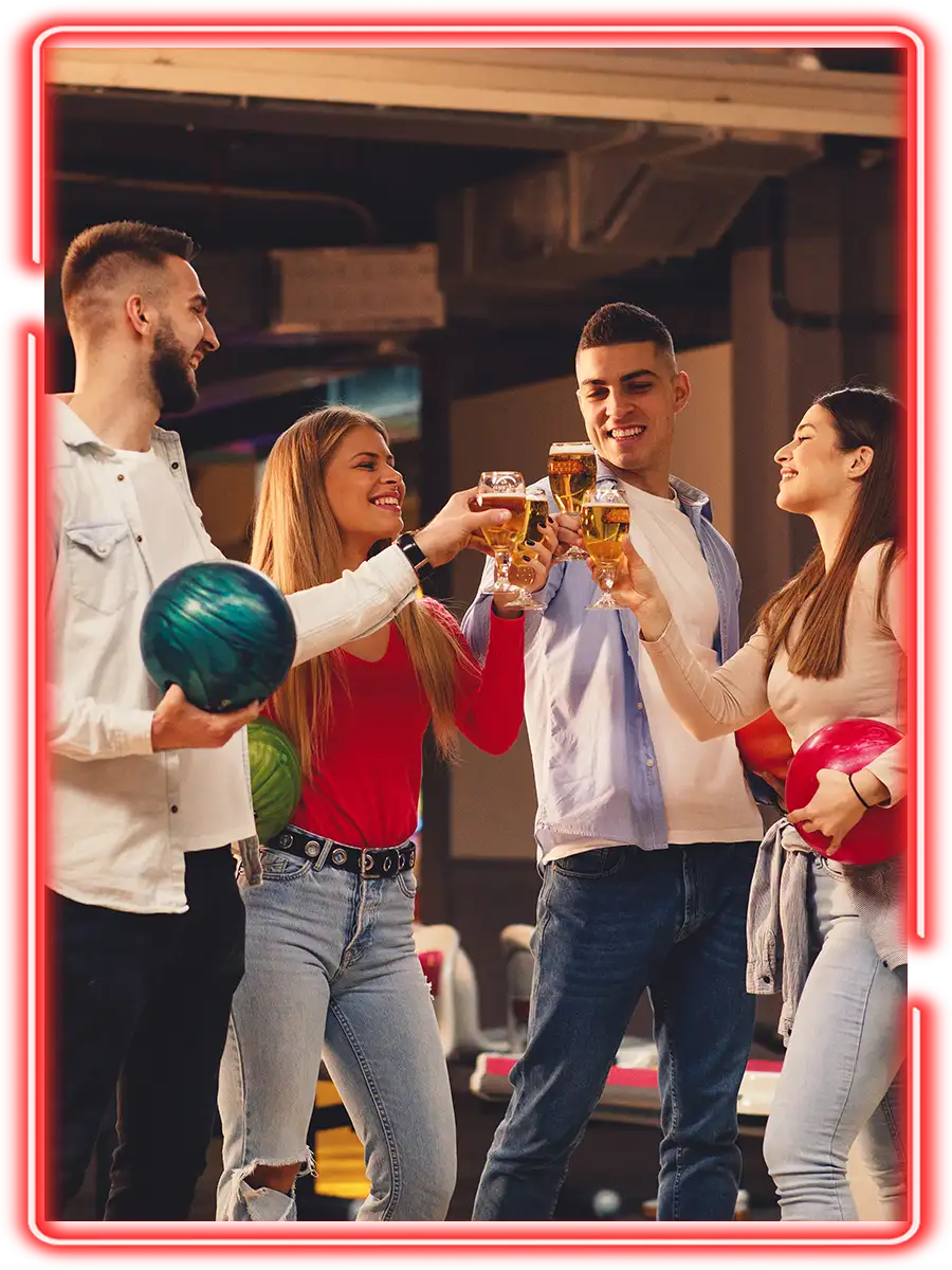 Friends toasting drinks while holding bowling balls at Championship Lanes in Anderson, IN - Team Building Events