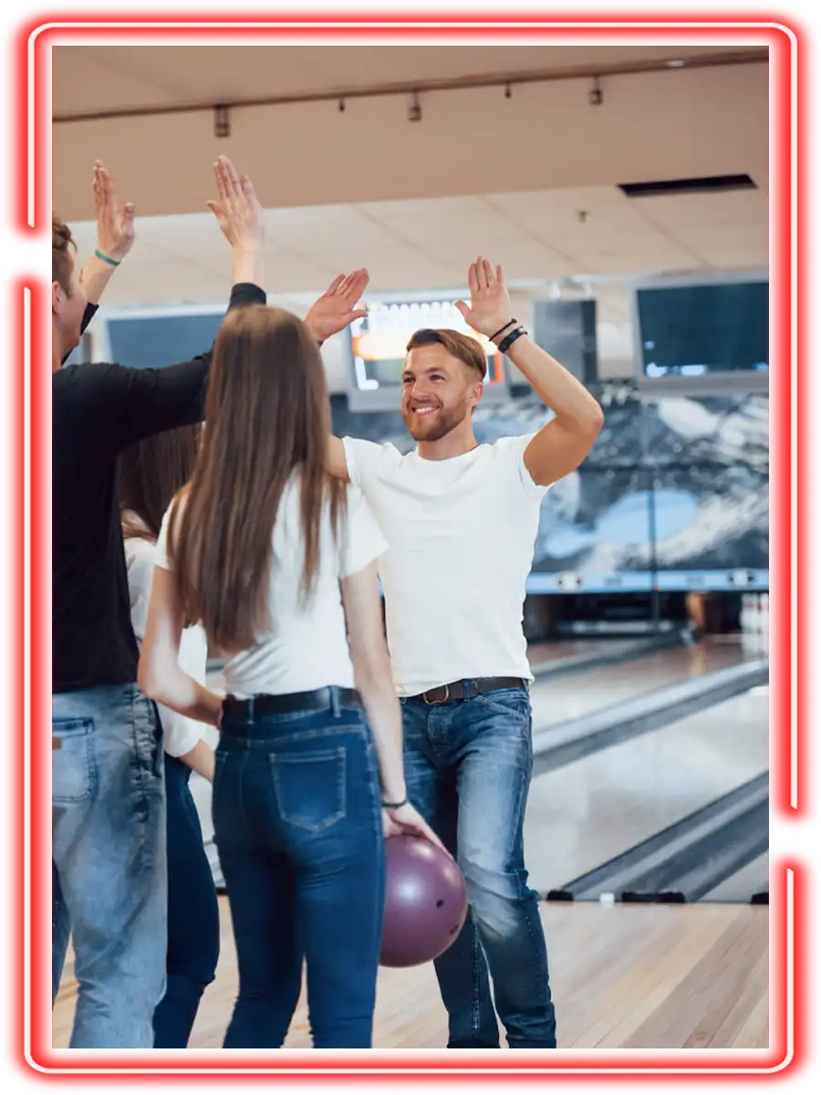 Group of friends high-fiving after a bowling win during a fundraising event at Championship Lanes in Anderson, IN